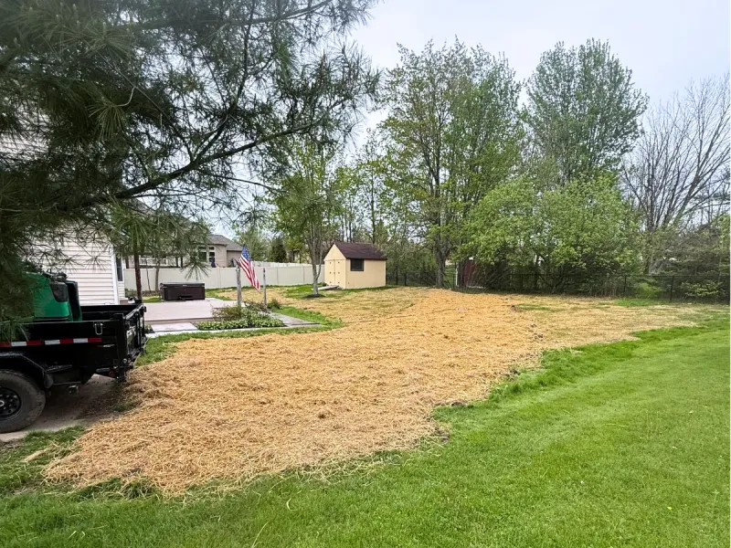 The same backyard finished and covered in straw after the french drain and regrade near Avon