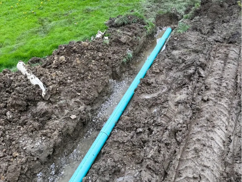 French drain pipe set in a gravel trench to drain a wet yard near Avon