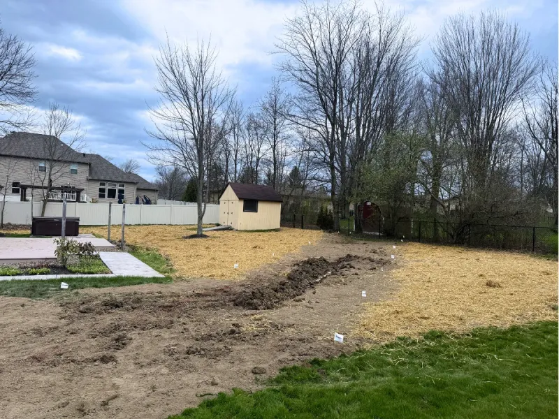 French drain being installed through a regraded backyard near Avon
